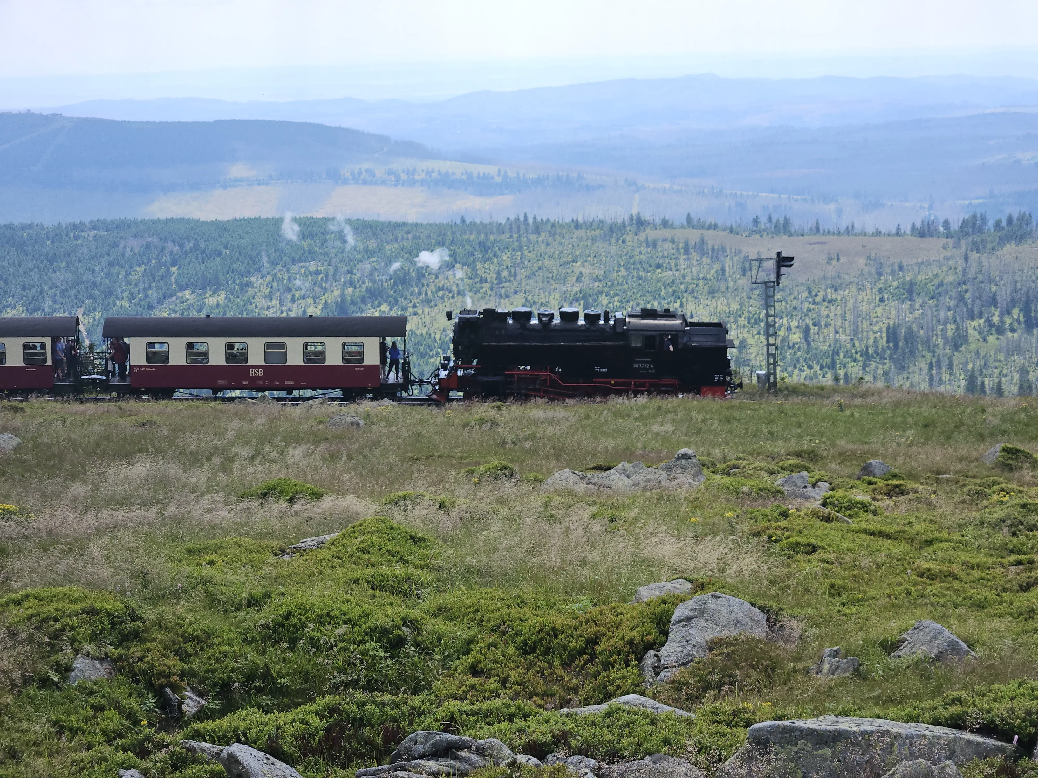 Die Brockenbahn - Dampflok - fährt nach unten ins Tal Richtung Schierke vor bergigem Harzpanorama